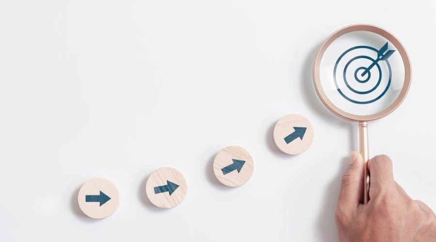 arrows aiming at circle wooden block with target_shutterstock_2388010639 900x500