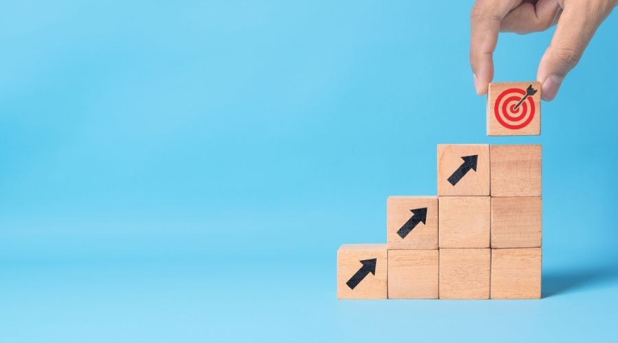 wooden blocks representing the conceptual process of innovation, planning, and achieving goals step by step_shutterstock_2649888975 900x500